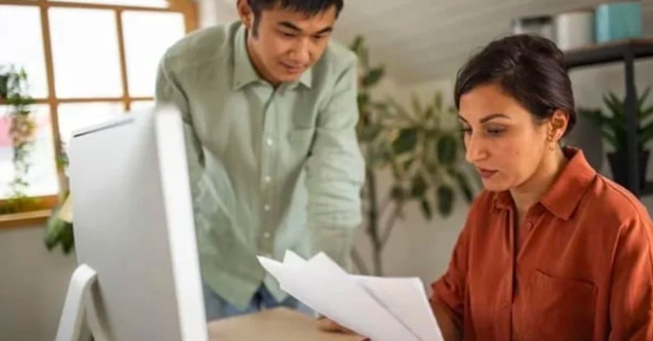 Two workers holding papers