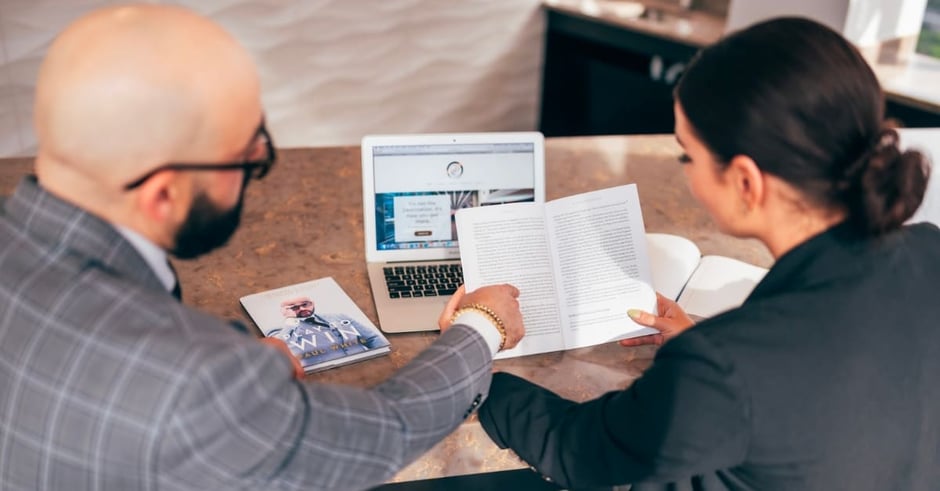 Two workers looking at a book