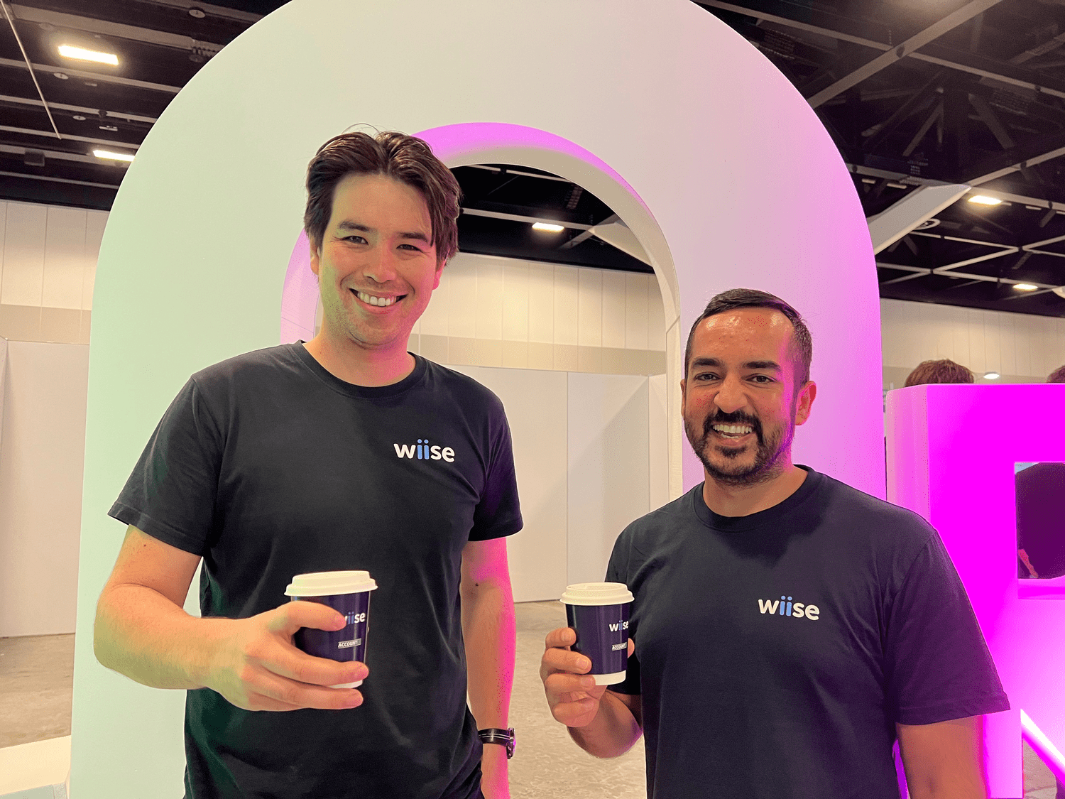 Chris and Ivneet smiling with coffee cups