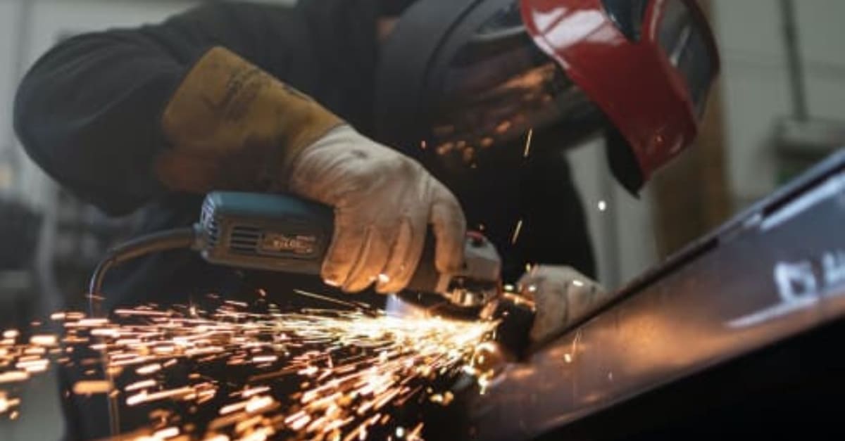 Man cutting steel with protective gear on