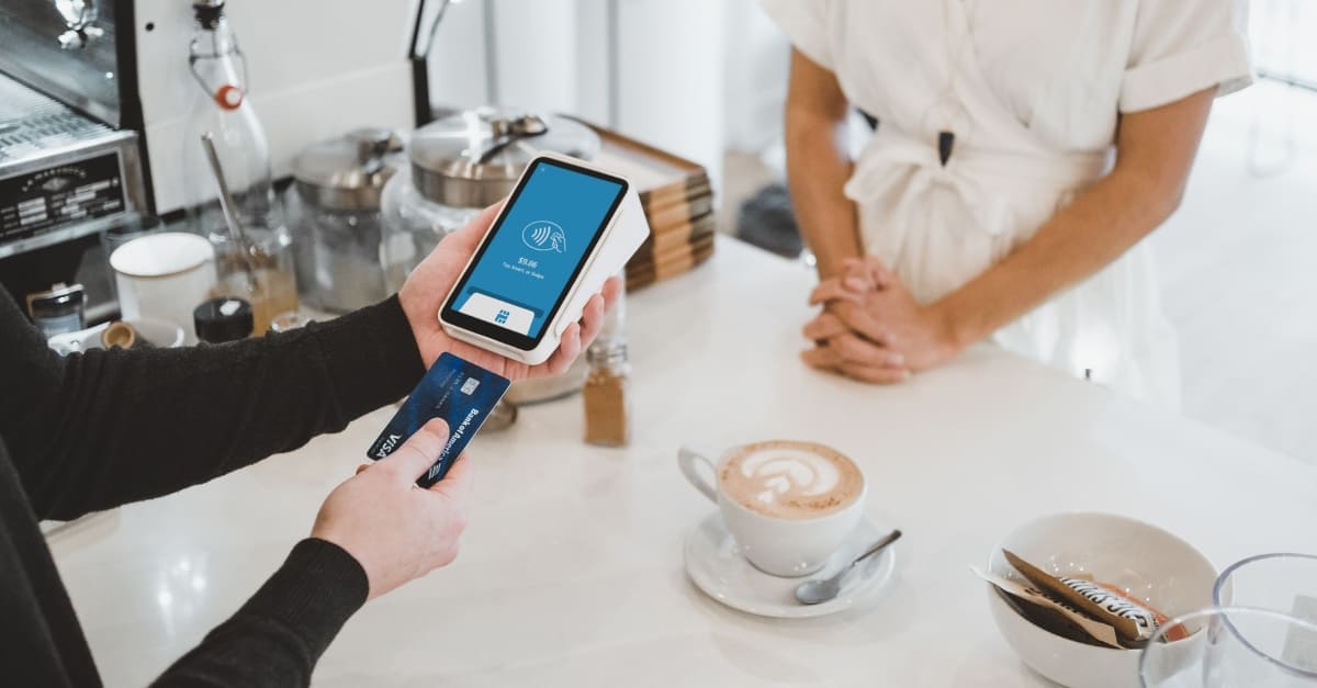 Person paying with a POS payment machine in a retail shop