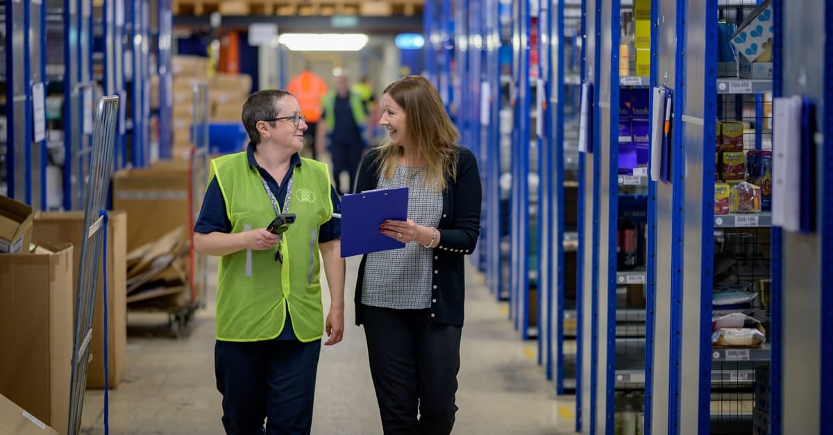 Two women walking through a warehouse