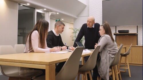 A team standing around a table discussing work