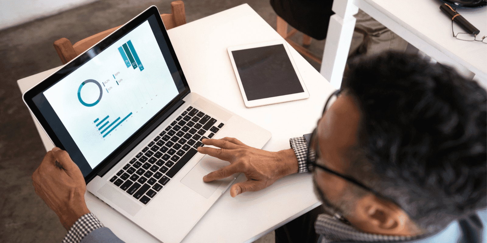 Man on his laptop with graphs displayed