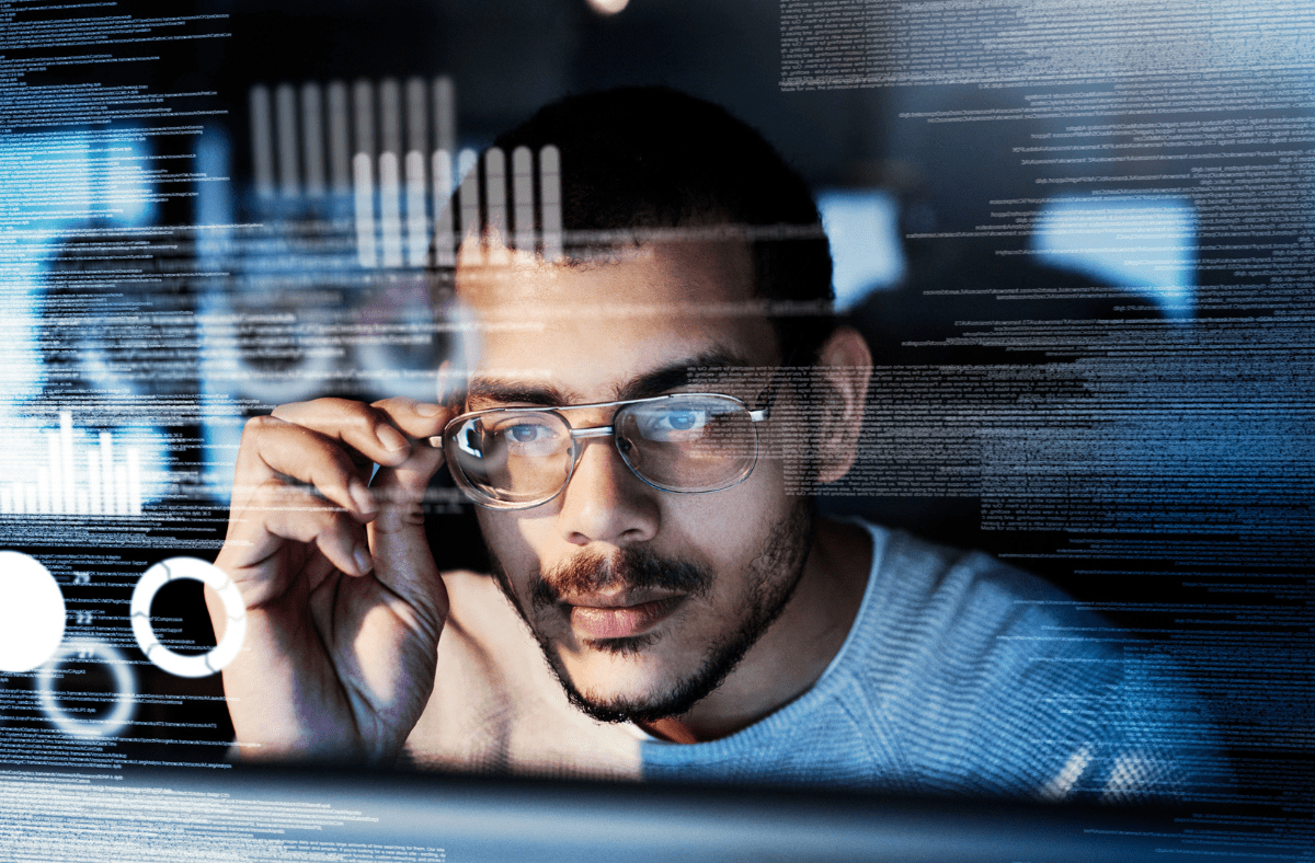 Man with glasses inspecting code
