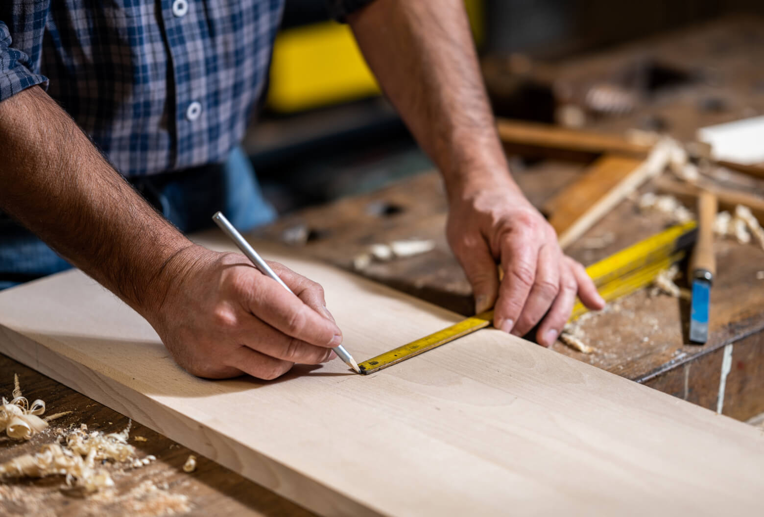 Man with measuring tape on wooden plank