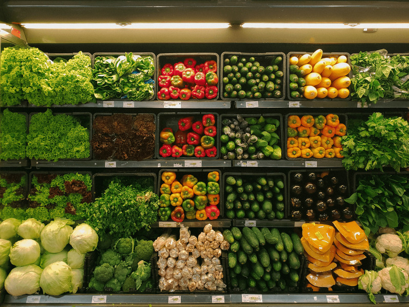 An image of shelves of vegetables such as broccoli and lettuce