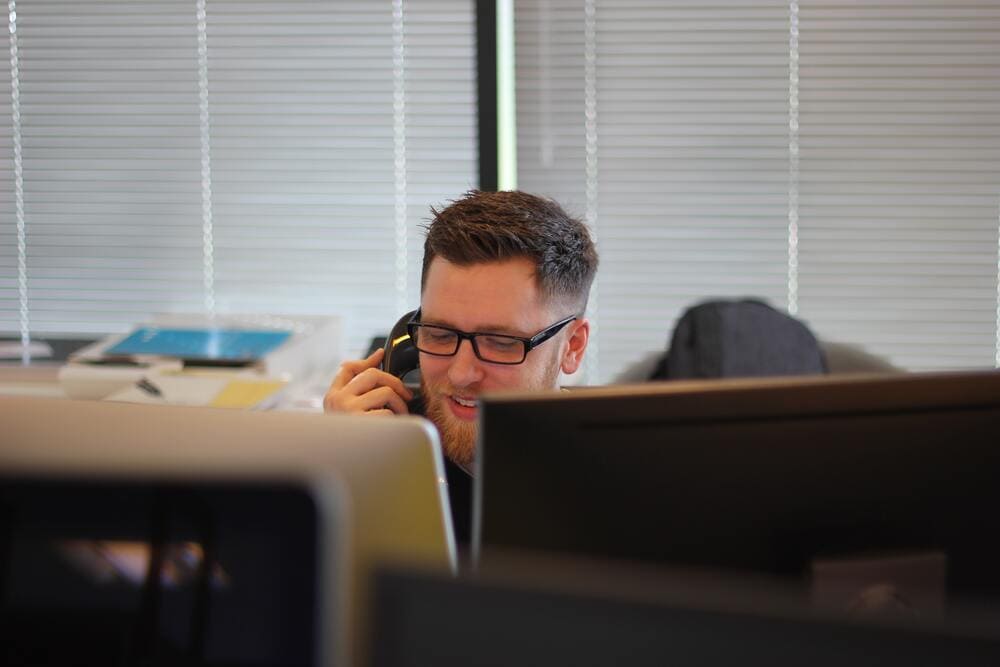 Man on phone in front of a computer