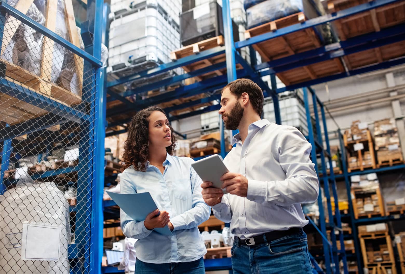 Two warehouse workers in front of shelves