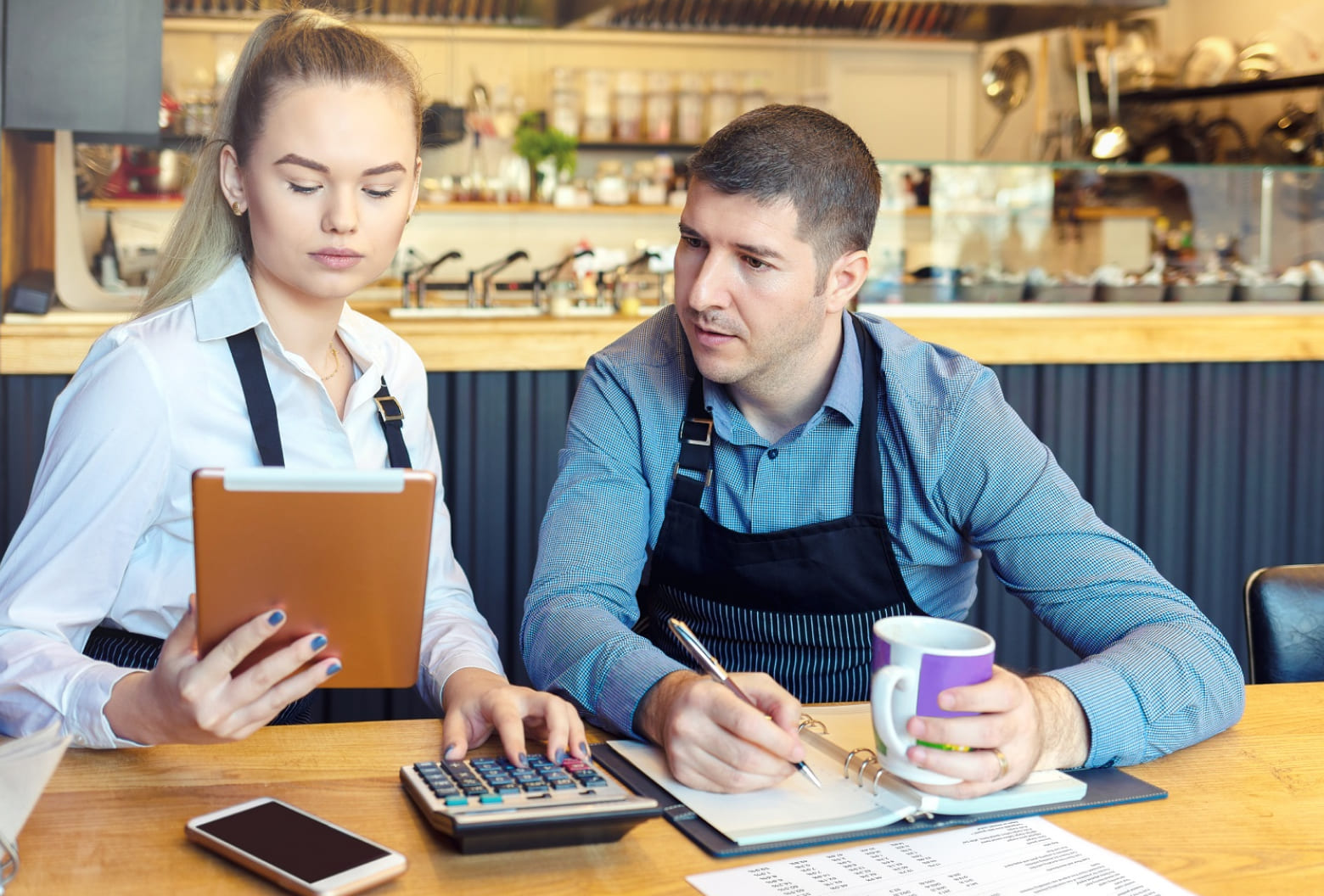 Two workers in a cafe counting