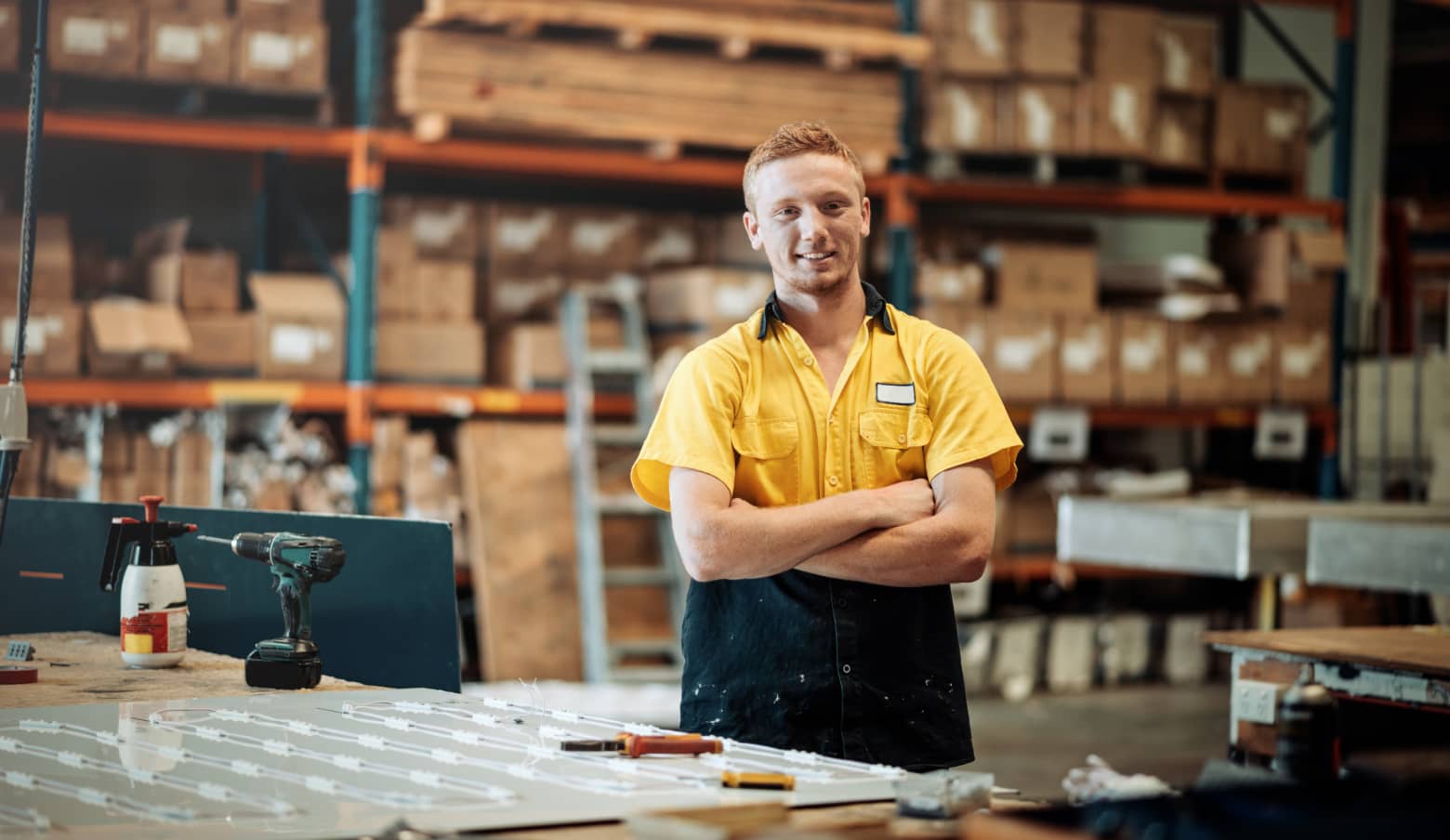 Warehouse worker with arms crossed smiling