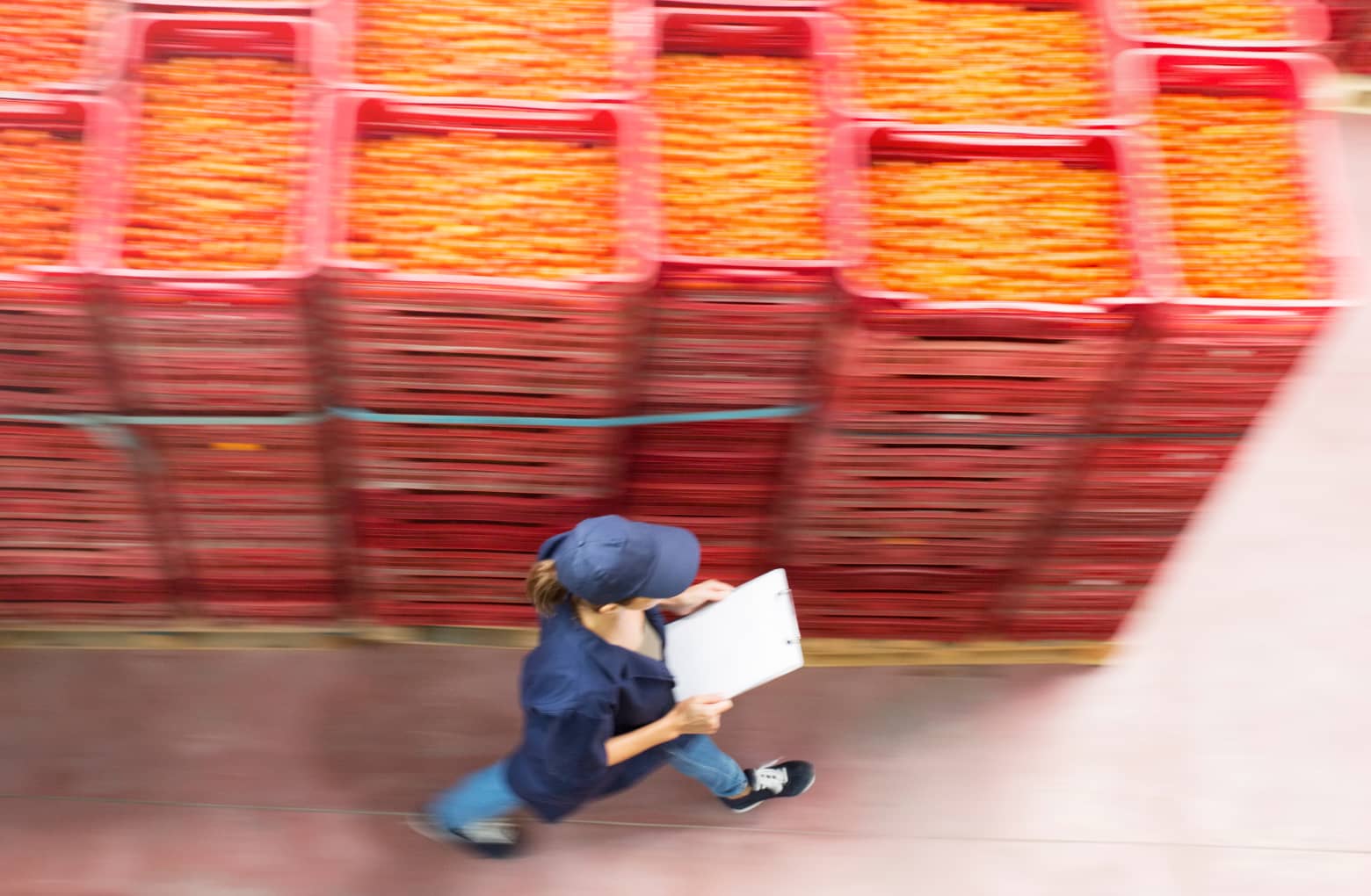 Woman in manufacturing walking past crates