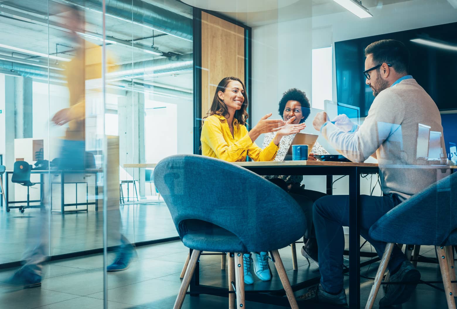 Workers sitting at desk in office talking