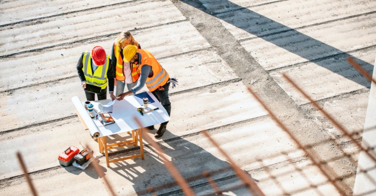 Workers together on a table with safety vests outside